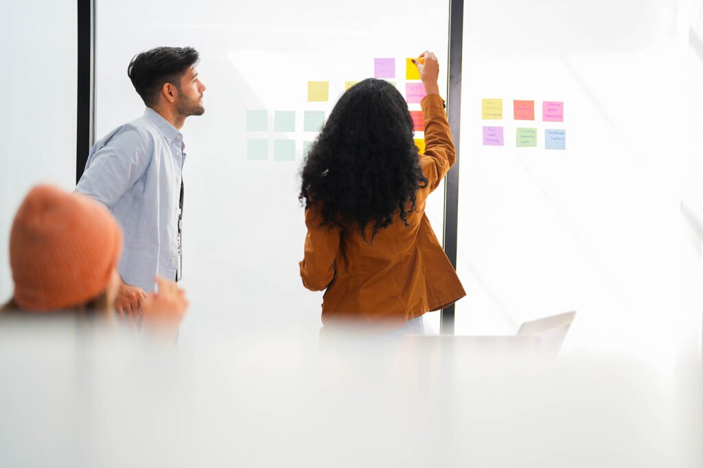 Fractional CMO. Marketing consultant engaging with team using transparent board